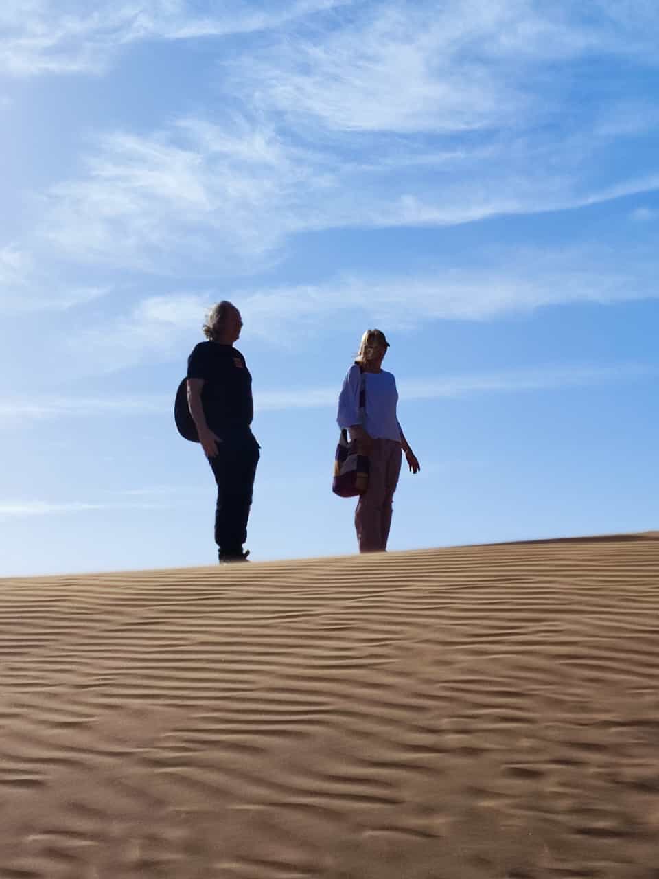 Dve osebi na vrhu peščene sipine pod modrim nebom, Festival pesnikov petih kontinentov, Laayoune, 2024