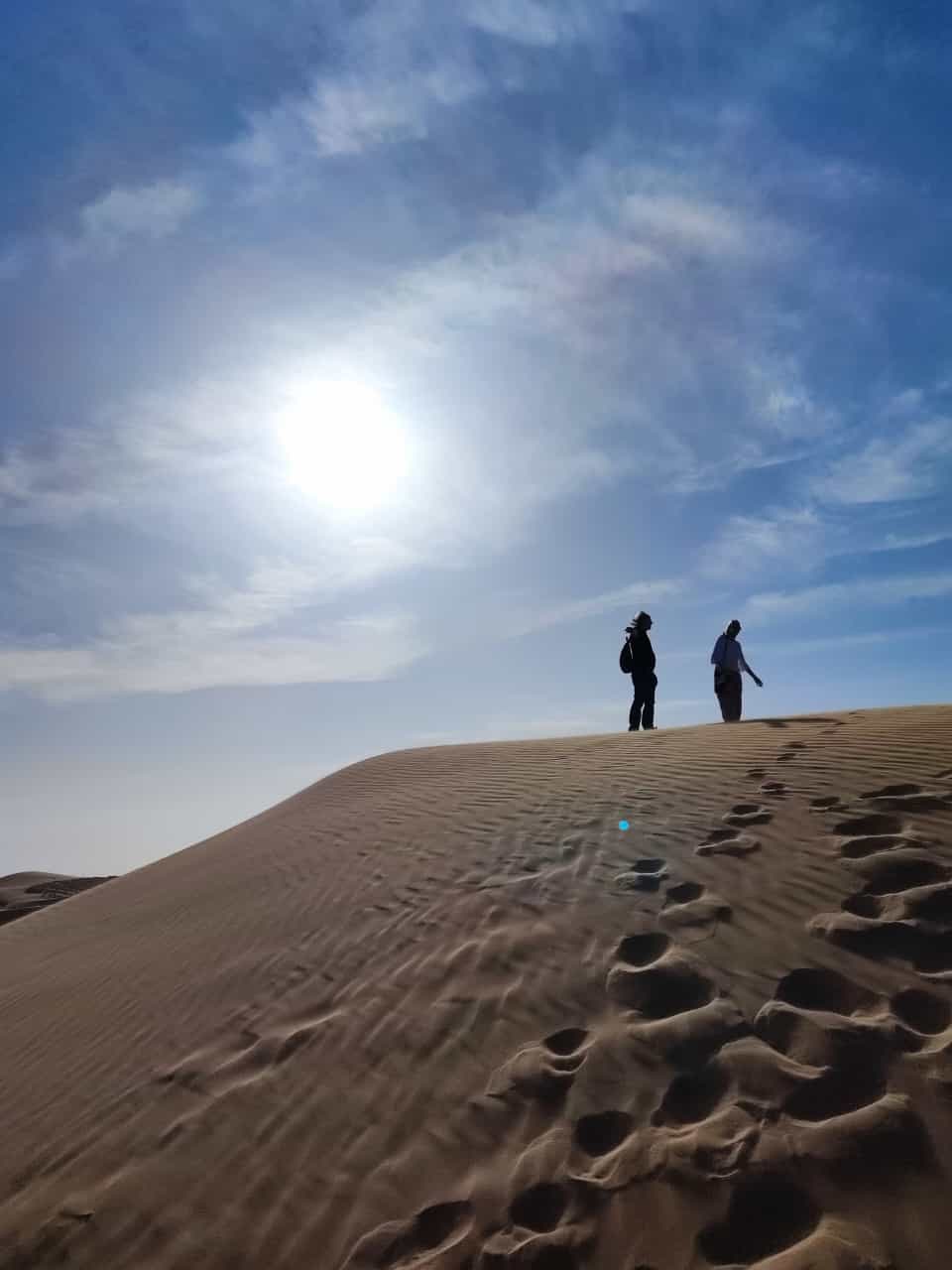 Silhueti dveh oseb na sipini proti soncu, Festival pesnikov petih kontinentov, Laayoune, 2024