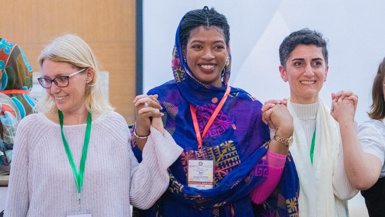 Udeleženke festivala z dvignjenimi sklenjenimi rokami, Festival pesnikov petih kontinentov, Laayoune, 2024
